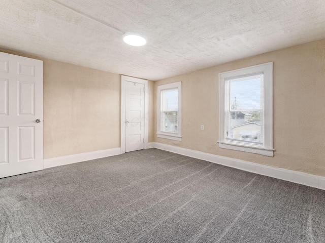 carpeted spare room featuring a textured ceiling