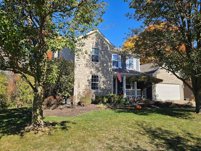 view of front of property featuring covered porch, a front yard, and a garage