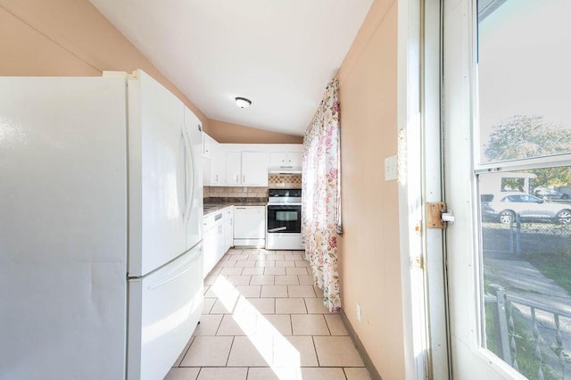 kitchen with lofted ceiling, white appliances, backsplash, white cabinets, and light tile patterned floors