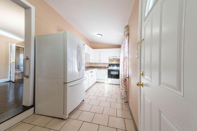 kitchen with tasteful backsplash, white appliances, light tile patterned floors, white cabinetry, and lofted ceiling