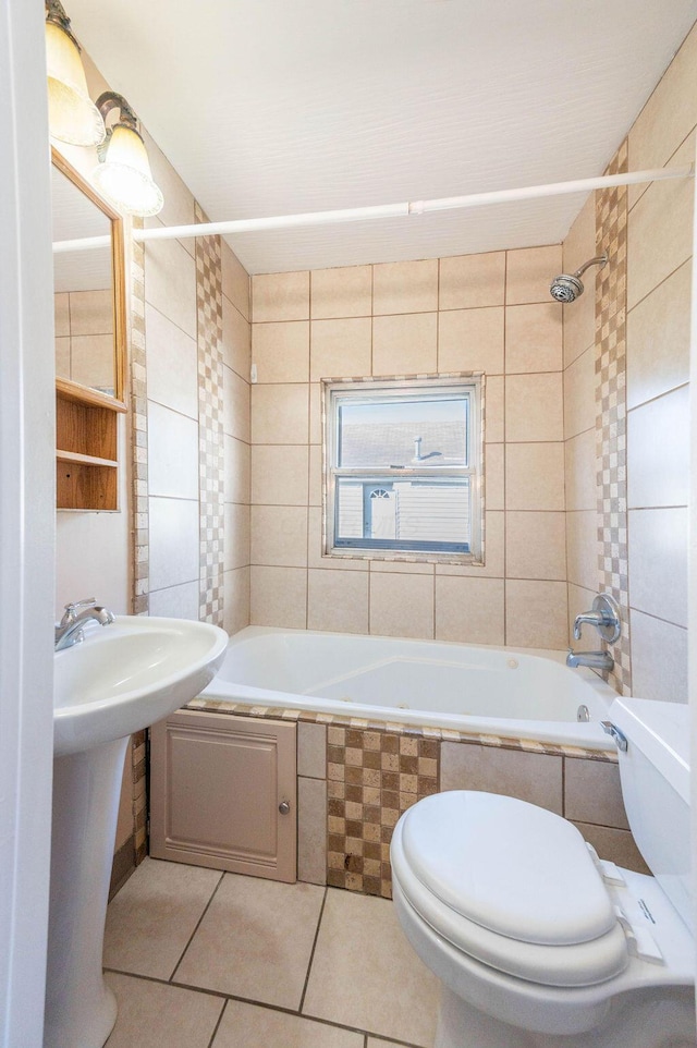 full bathroom with tile patterned flooring, toilet, tiled shower / bath, and sink