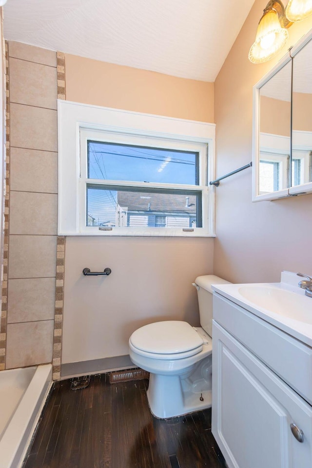 bathroom with vanity, lofted ceiling, toilet, walk in shower, and wood-type flooring