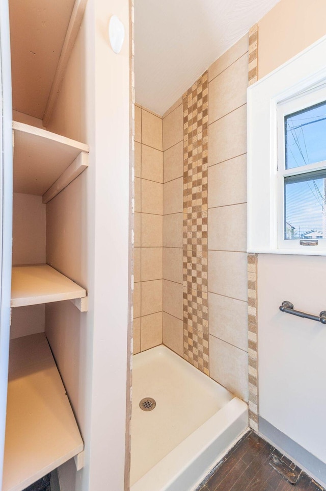 bathroom with hardwood / wood-style floors and tiled shower