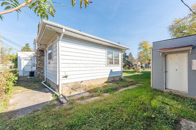 view of property exterior with a lawn and cooling unit