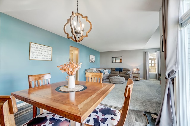 dining area featuring hardwood / wood-style flooring and an inviting chandelier