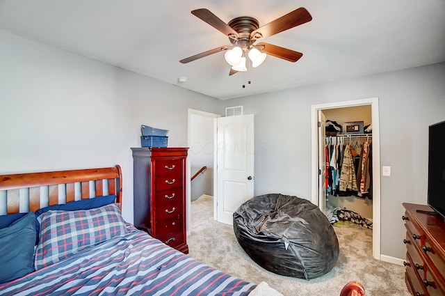 carpeted bedroom featuring a closet, a spacious closet, and ceiling fan