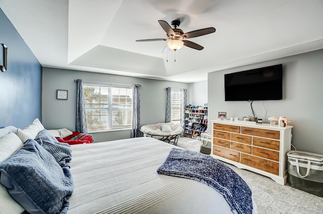 bedroom with carpet, ceiling fan, and a raised ceiling