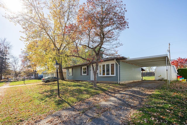 ranch-style home featuring a front yard and a carport