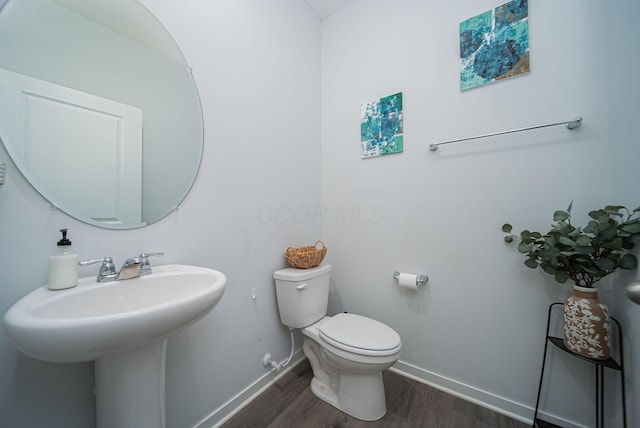 bathroom featuring hardwood / wood-style flooring, toilet, and sink