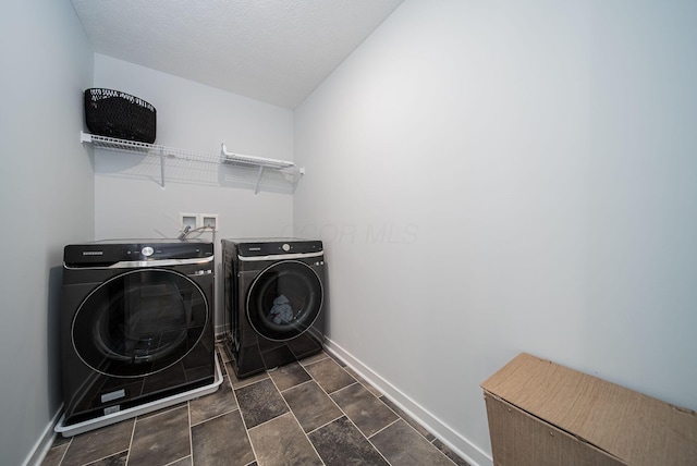 laundry room featuring a textured ceiling and washing machine and clothes dryer