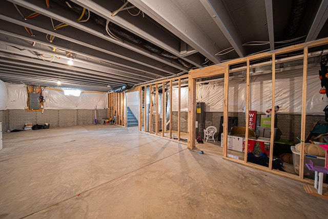 basement featuring electric panel and electric water heater