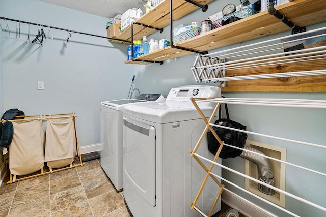 laundry room with washing machine and dryer, laundry area, and stone finish floor