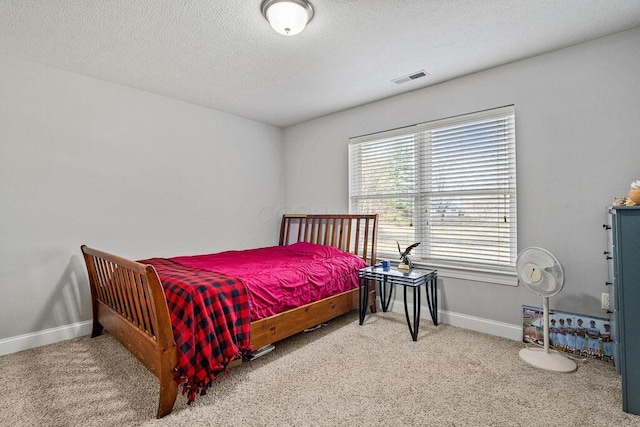 bedroom with visible vents, baseboards, a textured ceiling, and carpet flooring