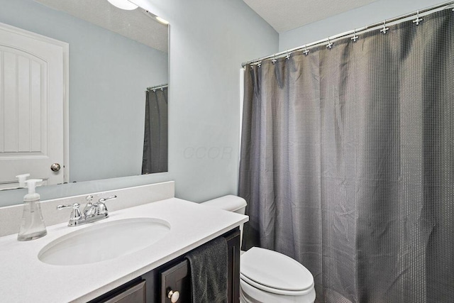 bathroom featuring vanity, toilet, and a textured ceiling