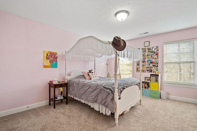 bedroom with visible vents, baseboards, a textured ceiling, and carpet flooring