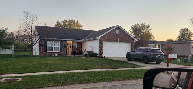 ranch-style house with a garage and a yard