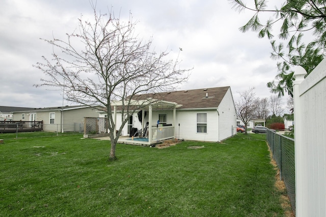 rear view of property with a yard and a deck