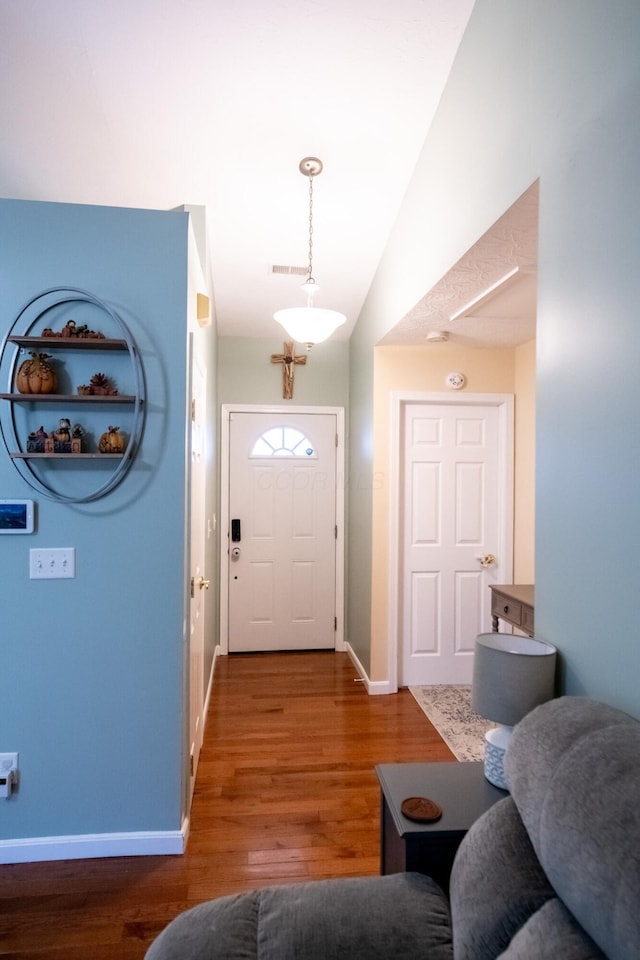 entrance foyer featuring dark wood-type flooring and vaulted ceiling