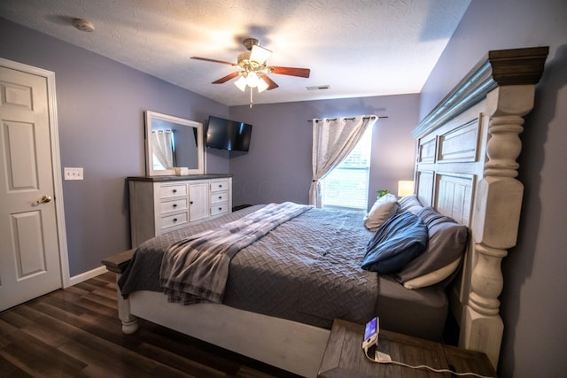 bedroom with dark hardwood / wood-style flooring, a textured ceiling, and ceiling fan