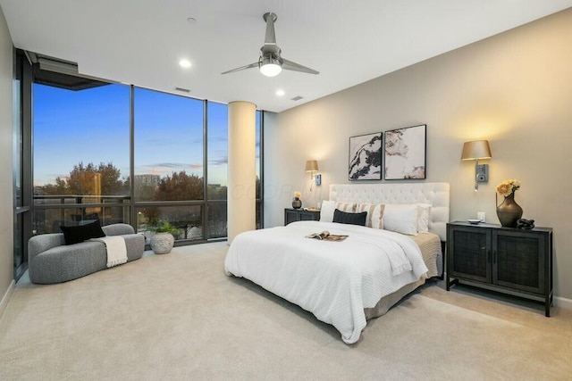 carpeted bedroom with ceiling fan and a wall of windows