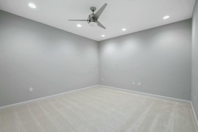 empty room featuring ceiling fan and light colored carpet