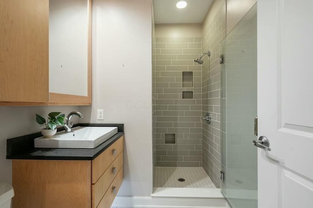 bathroom with vanity and a tile shower