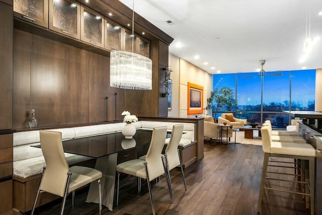 bar featuring pendant lighting, dark brown cabinetry, ceiling fan, and dark wood-type flooring