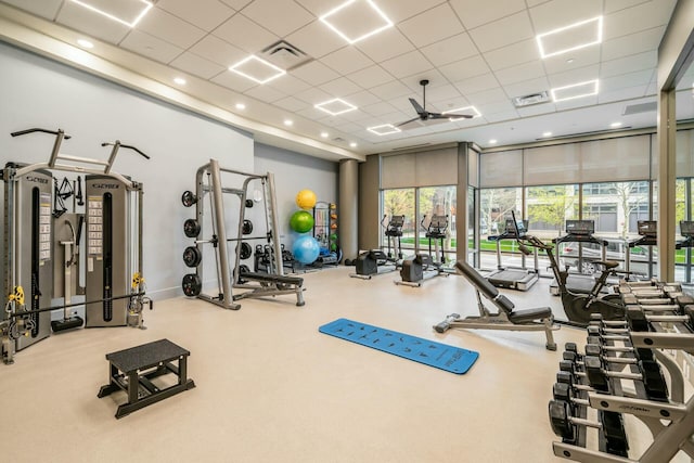 gym featuring ceiling fan and a drop ceiling