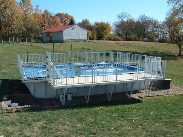 view of swimming pool with a lawn and a rural view