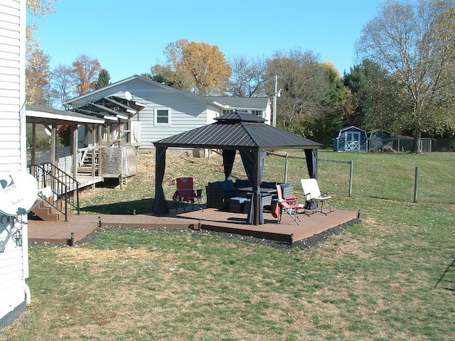 view of yard featuring outdoor lounge area, a gazebo, a deck, and a storage shed