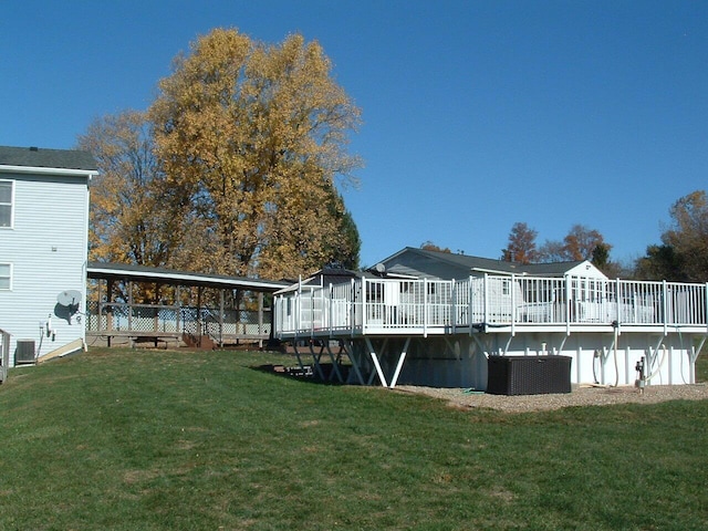 back of house featuring a lawn, a wooden deck, and central AC