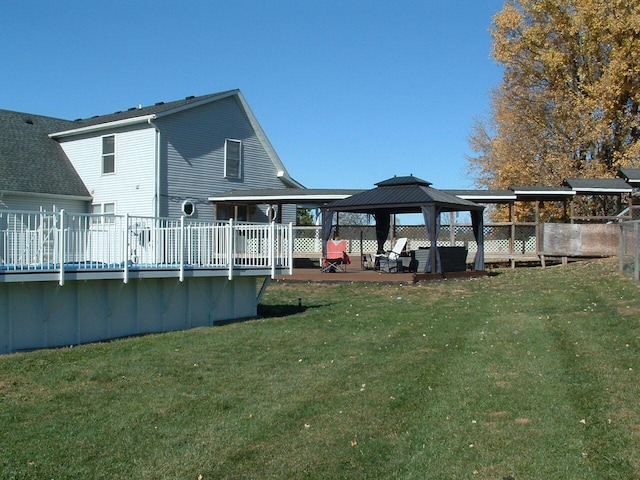 rear view of house with a gazebo, a yard, and a wooden deck