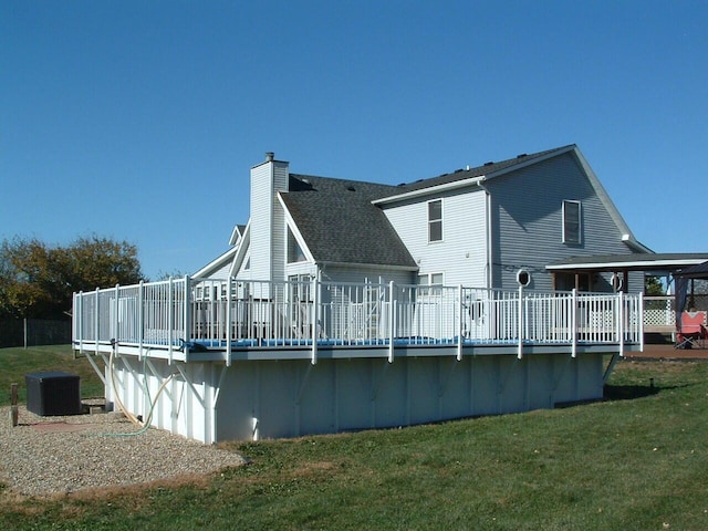 back of property with a lawn and a wooden deck