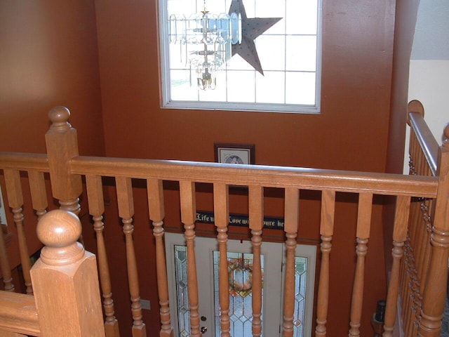 staircase with a notable chandelier