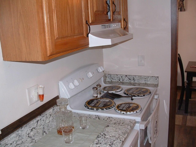 kitchen with ventilation hood, light stone countertops, and white electric stove