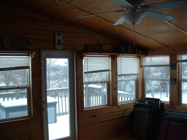 sunroom featuring lofted ceiling, ceiling fan, and wood ceiling