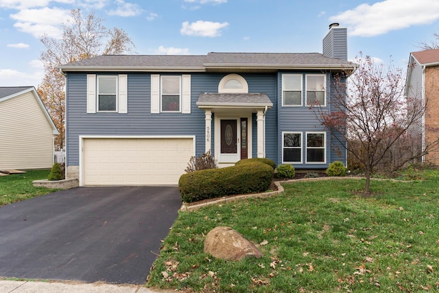 bi-level home featuring a garage and a front lawn