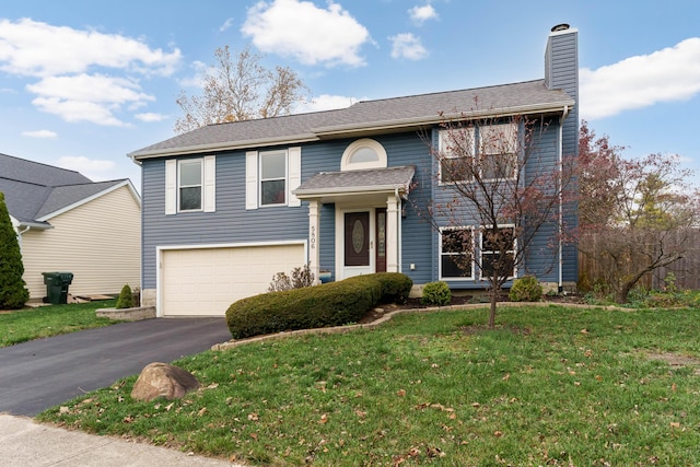 split foyer home featuring a garage and a front yard