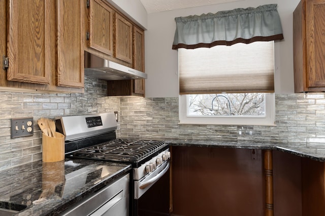 kitchen featuring dark stone counters, a textured ceiling, decorative backsplash, and stainless steel gas range oven