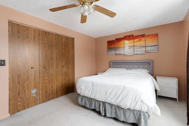 carpeted bedroom with a textured ceiling and ceiling fan