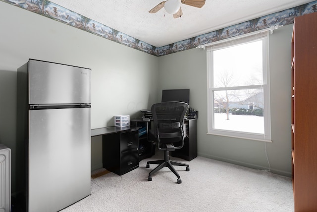 carpeted home office featuring ceiling fan and a textured ceiling