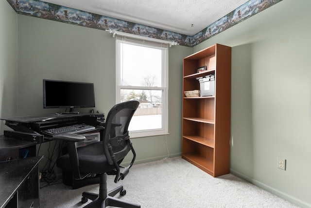 carpeted office space featuring a textured ceiling