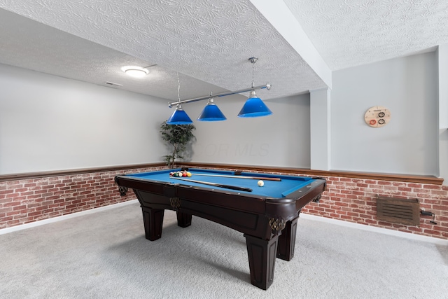 playroom with pool table, brick wall, light colored carpet, and a textured ceiling