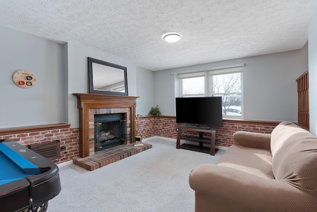 living room with brick wall, light carpet, a brick fireplace, and a textured ceiling