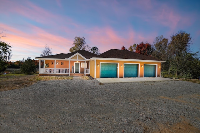 ranch-style house featuring a porch and a garage