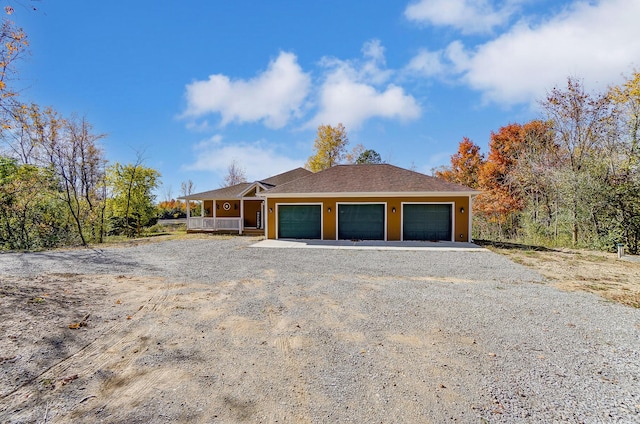 single story home with a porch and a garage