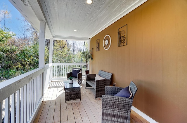 wooden terrace with an outdoor living space