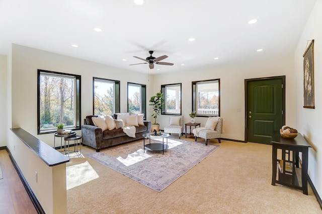 carpeted living room with a wealth of natural light and ceiling fan