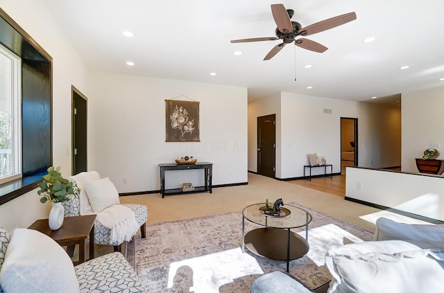 carpeted living room with ceiling fan