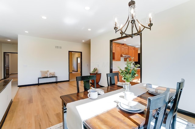 dining area with a chandelier and light wood-type flooring